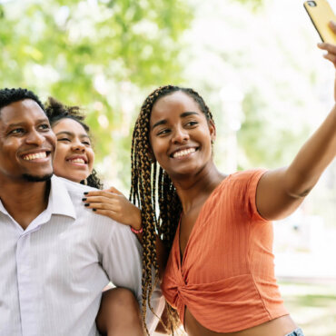 african-american-family-having-fun-and-enjoying-a-day-at-the-park-while-taking-a-selfie-together-with-a-mobile-phone